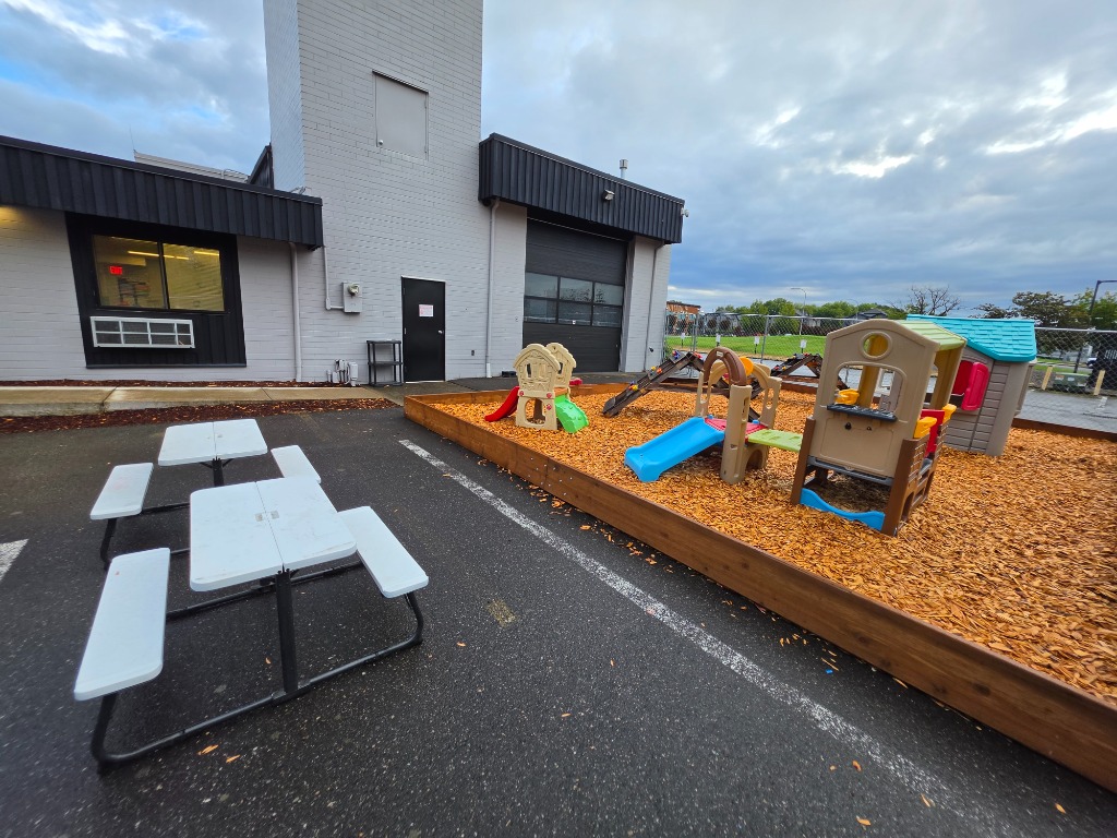 Harwell School Beaverton fenced outdoor playground with slides and playhouse